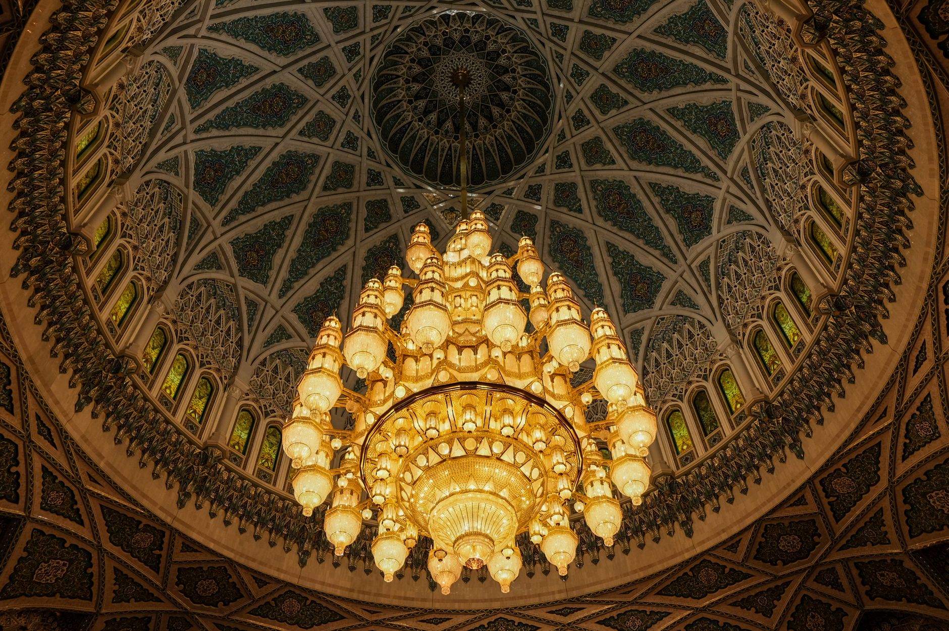 The ornate crystal chandelier and dome of the Sultan Qaboos Grand Mosque