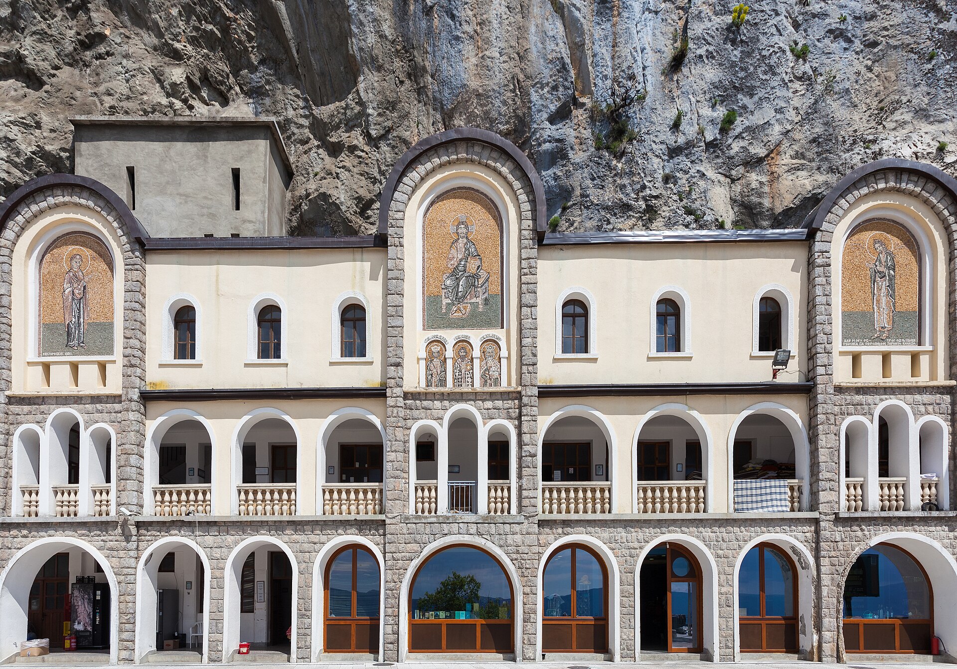 The arcaded front of the lower church at Ostrog, full-length painted saints set on the wall between the arches
