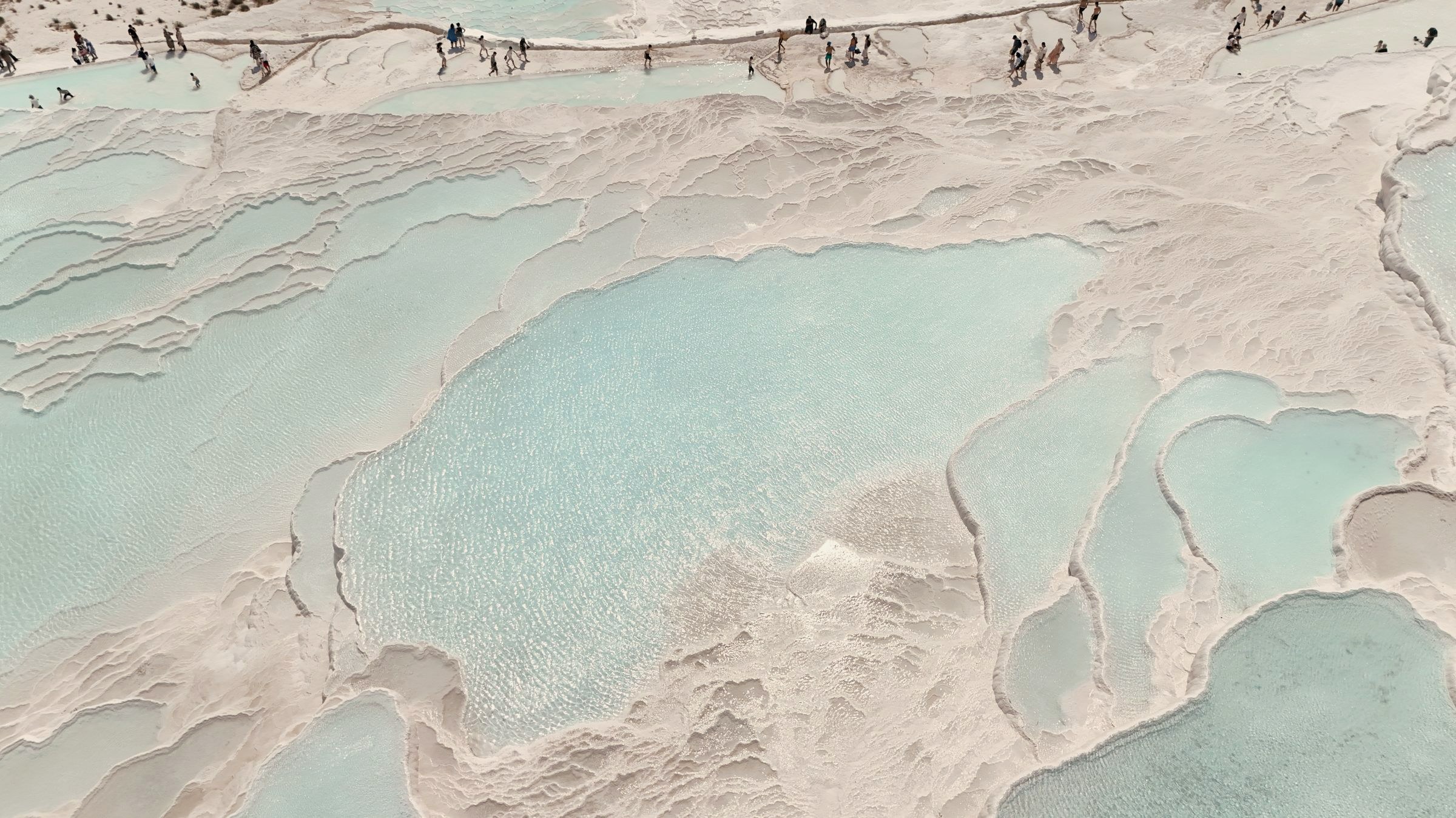 Aerial view of Pamukkale's white travertine terraces and turquoise pools from above