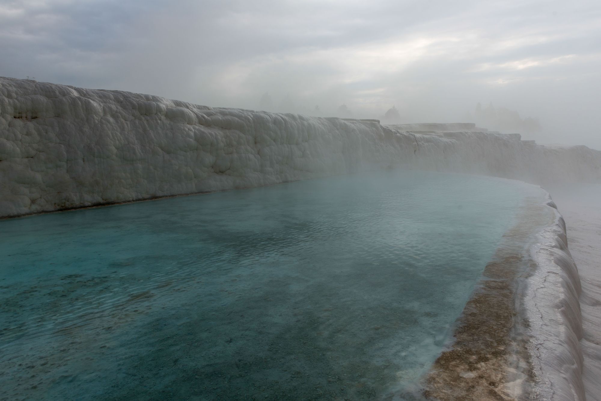 Mist rising off the warm thermal springs of Pamukkale at first light