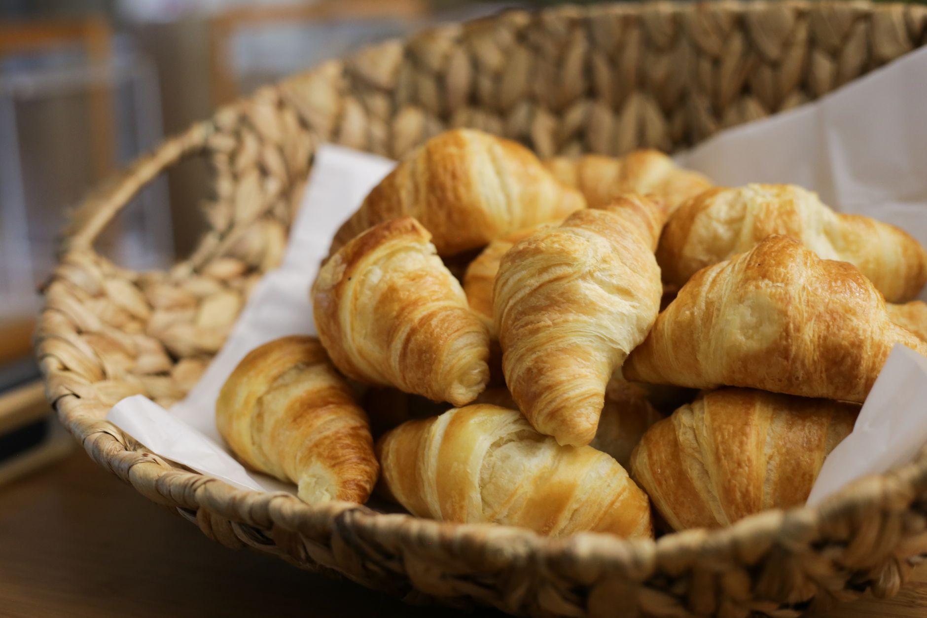 Fresh golden croissants in a basket at a French bakery