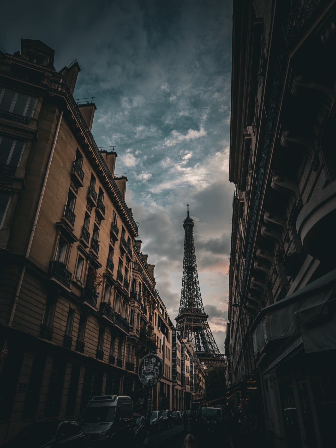 The Eiffel Tower at dusk from a narrow Paris street