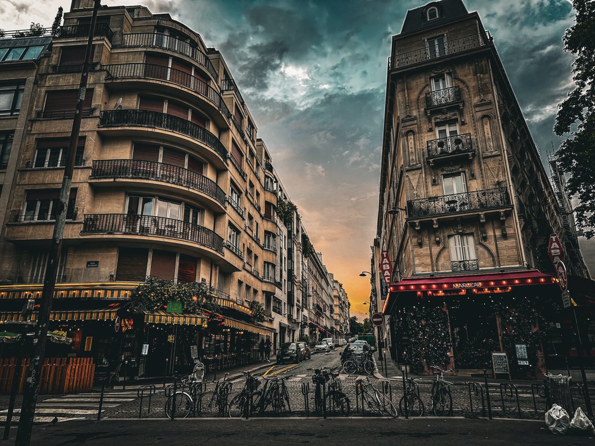 A Paris street with cafés at dusk