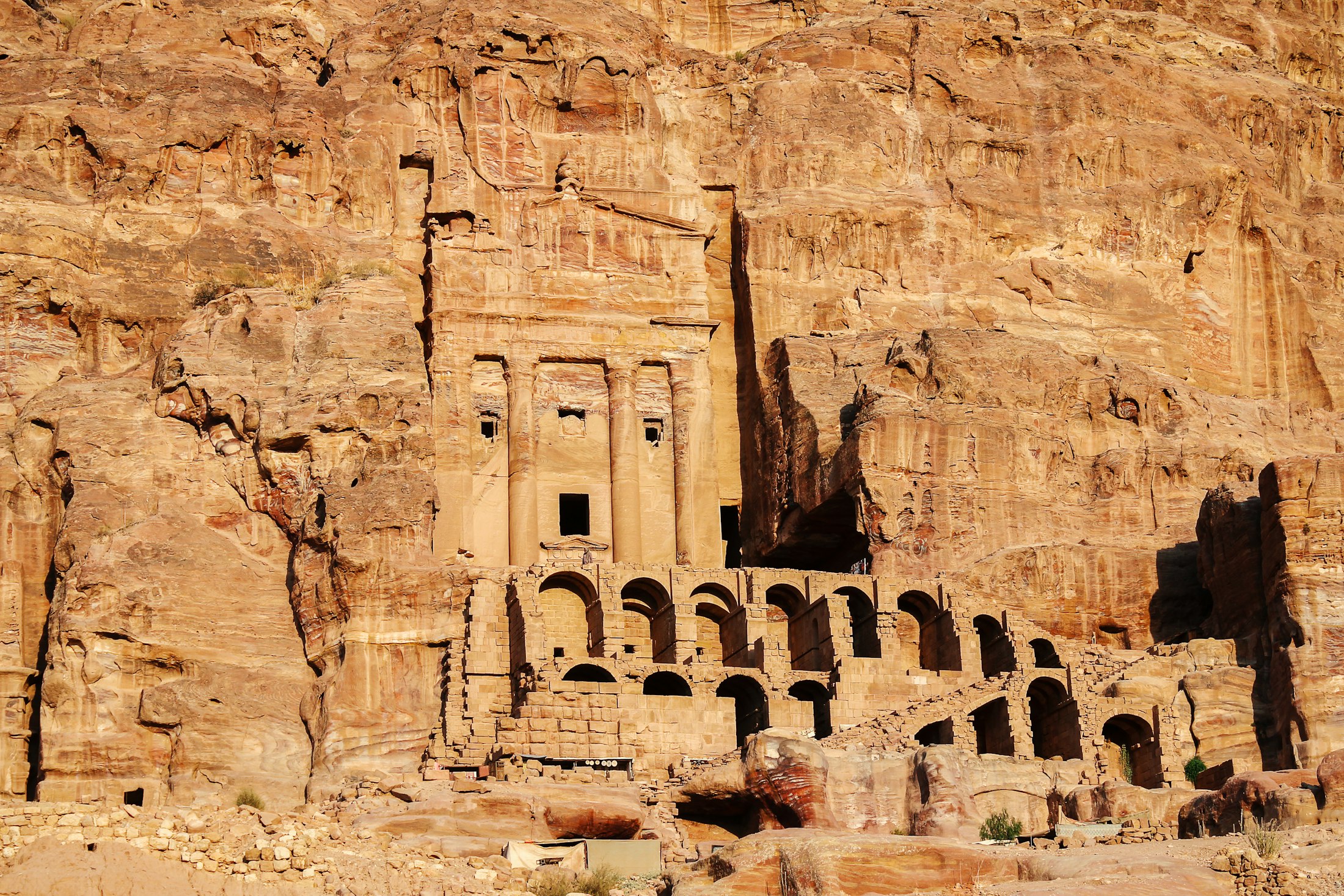 The weathered facades of the Royal Tombs cut into a cliff at Petra