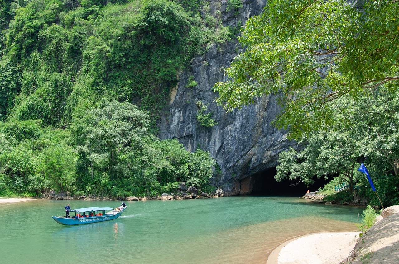 Boats on the turquoise Son river below the karst cliffs at Phong Nha