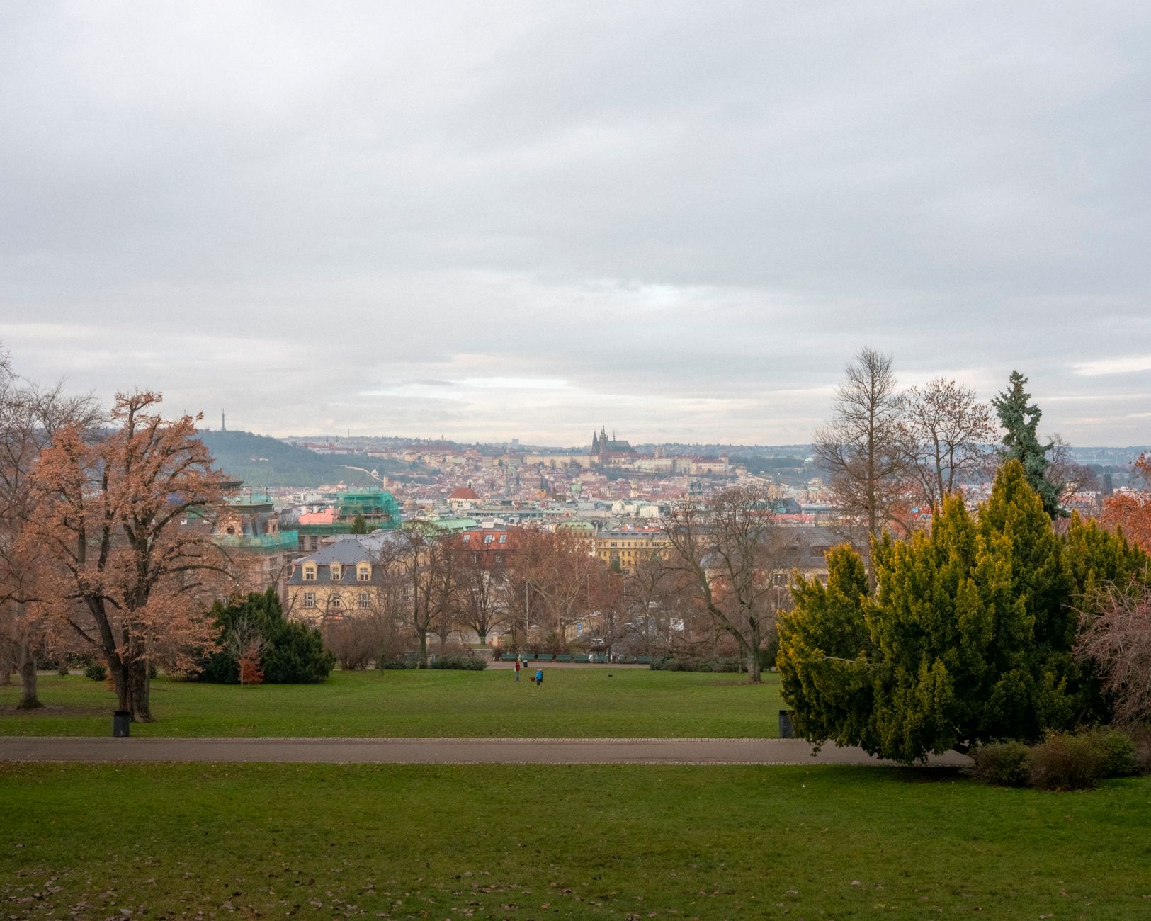An open park lawn at Letná above Prague, the castle and Petřín tower in the distance