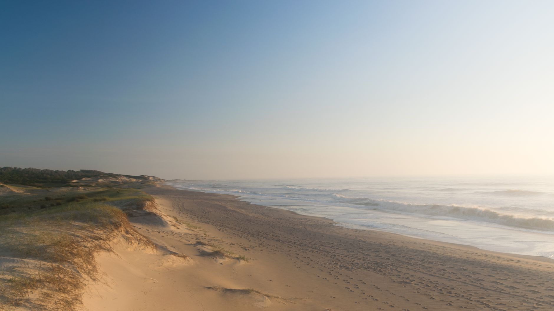 An open 4x4 truck crossing the sand dunes toward Cabo Polonio