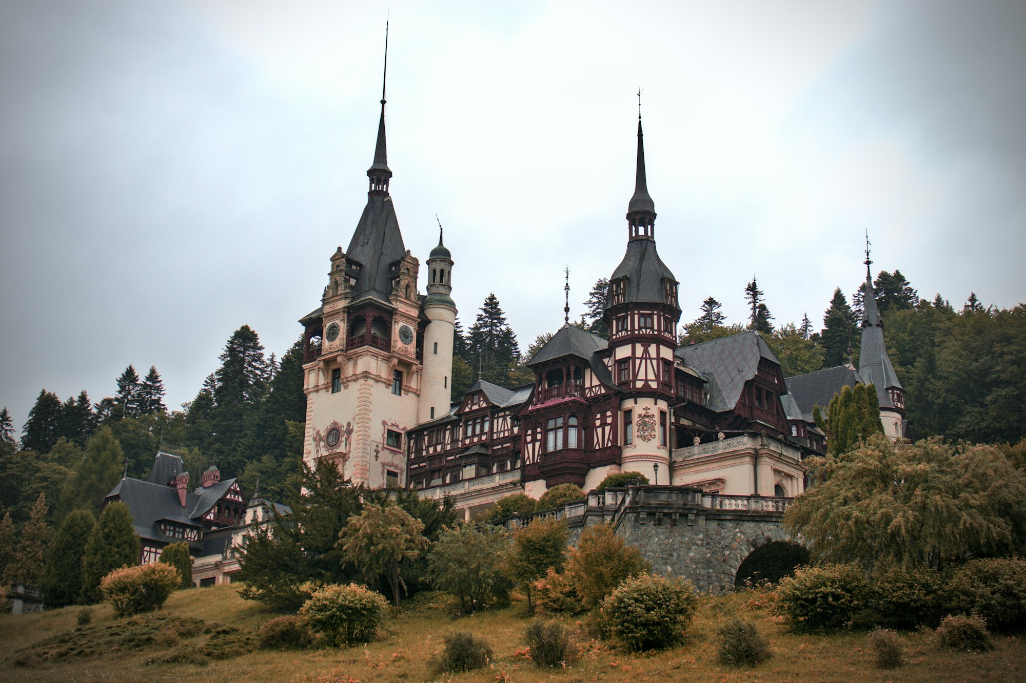 Peles Castle, an ornate royal palace among forested mountains at Sinaia