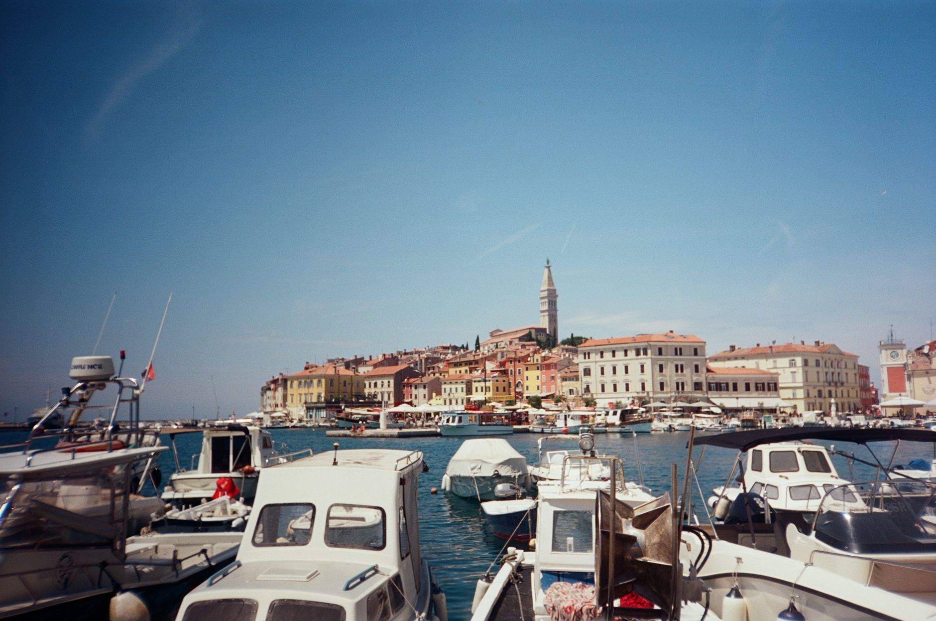 Fishing and excursion boats moored in Rovinj harbour with the old town and campanile behind