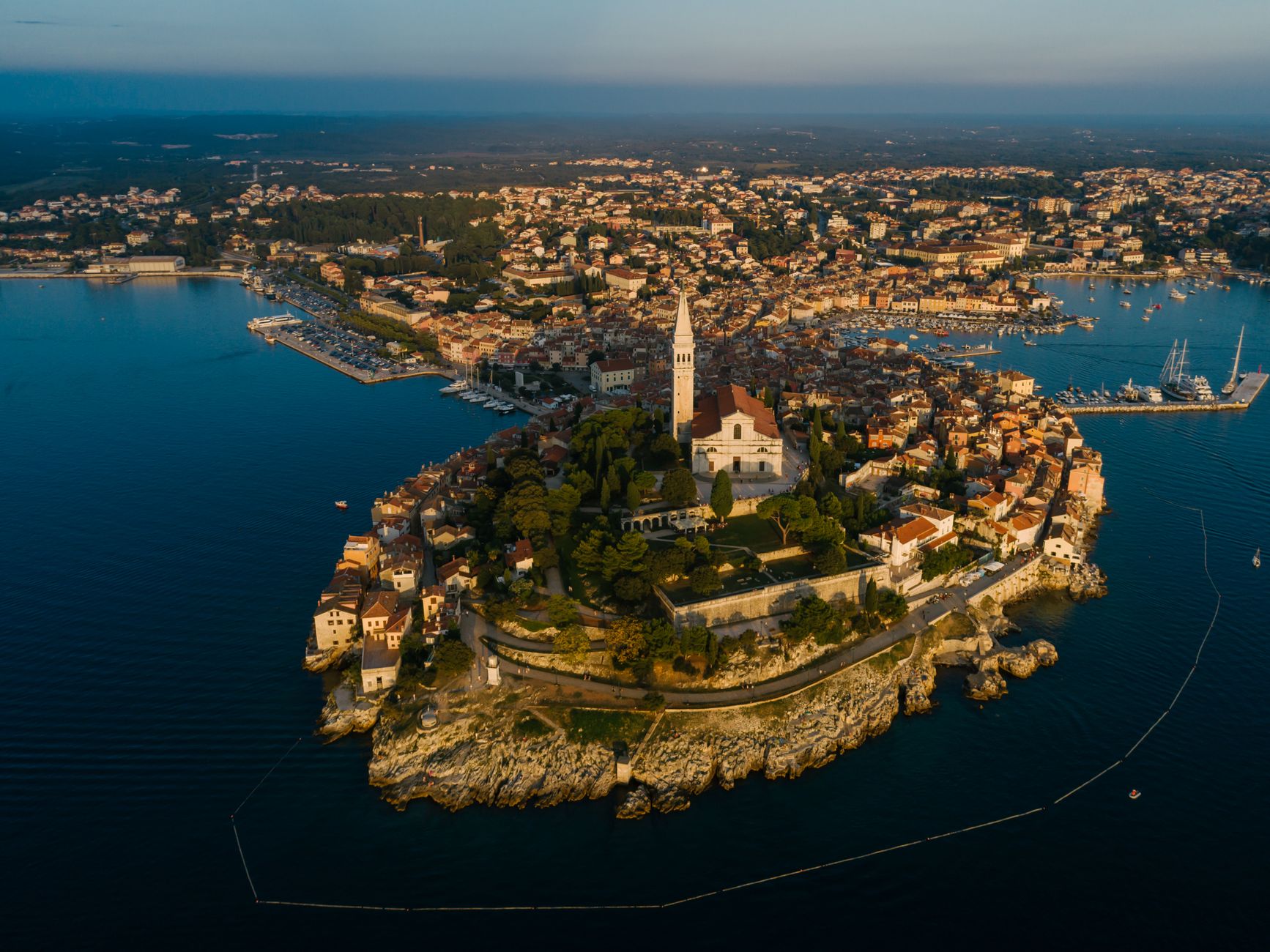 An aerial view at dusk of the Rovinj peninsula, its old town packed around the church and campanile