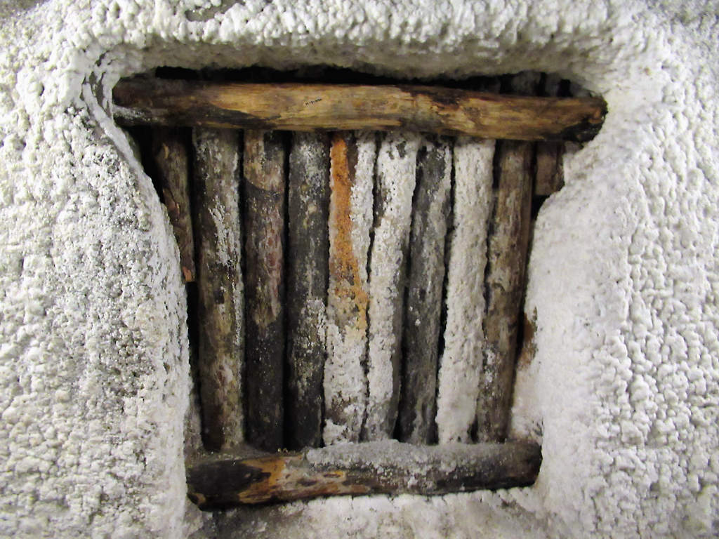 Timber baulks set into a salt wall, encrusted with white salt