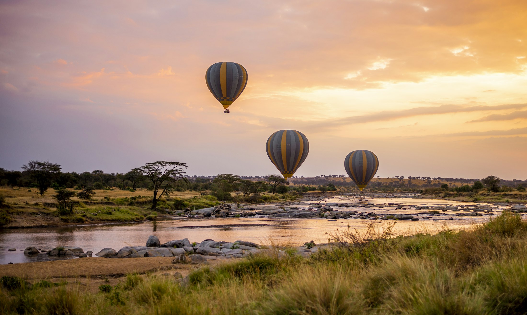A hot-air balloon drifting over the Serengeti plains at dawn
