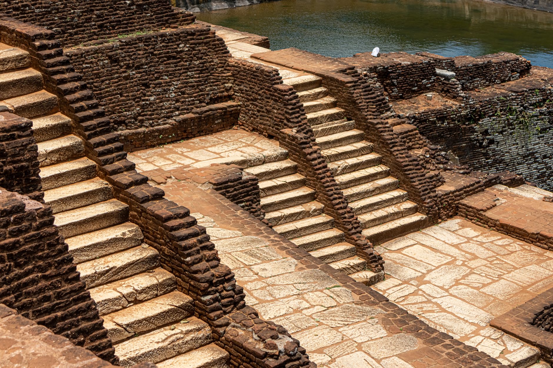 Ancient brick and stone steps running down to a bathing pool in the Sigiriya gardens