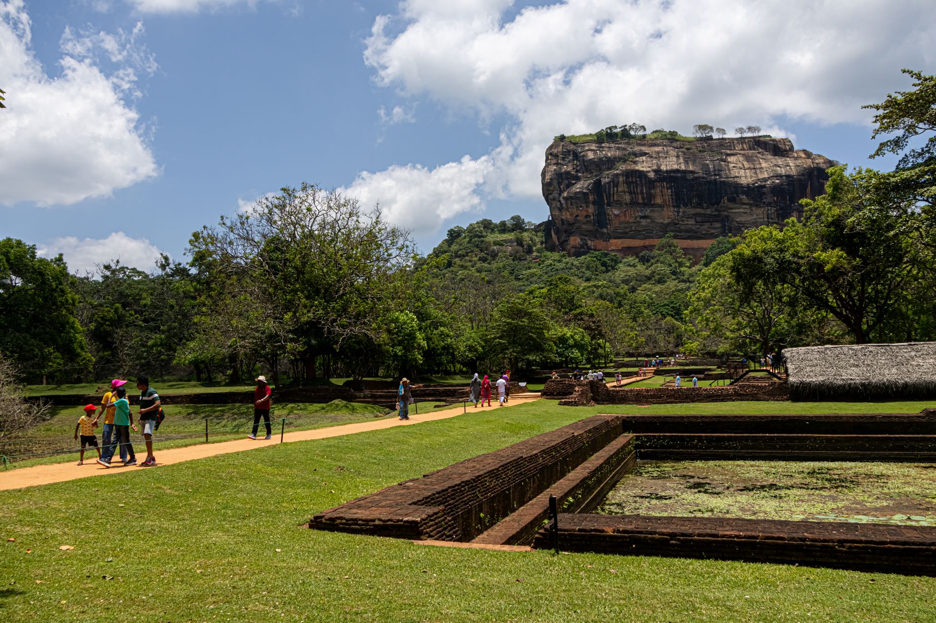 Brick-lined water tank in the royal gardens with Sigiriya rock behind