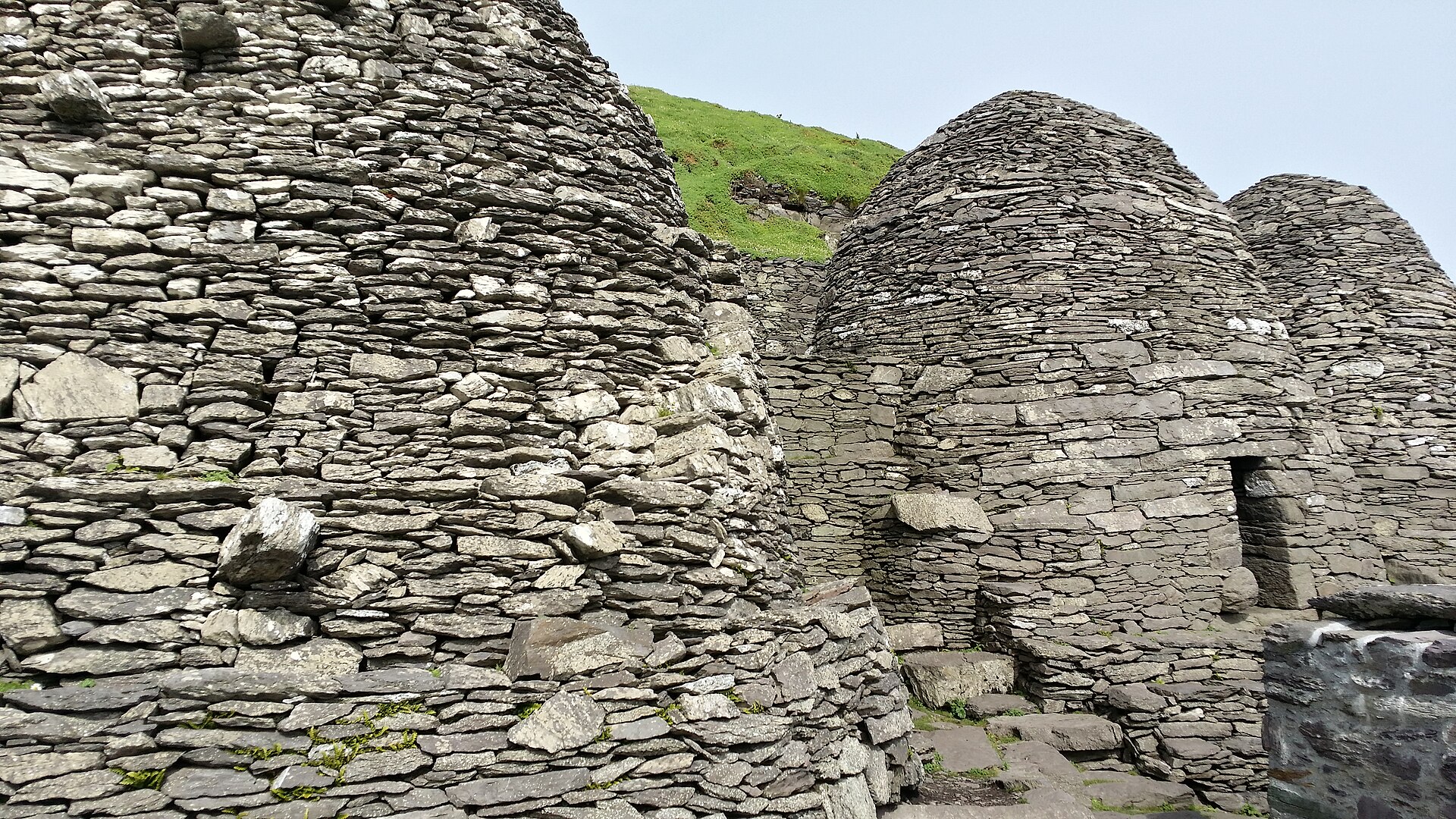Drystone corbelled beehive cells on Skellig Michael, dark slate courses and a low doorway