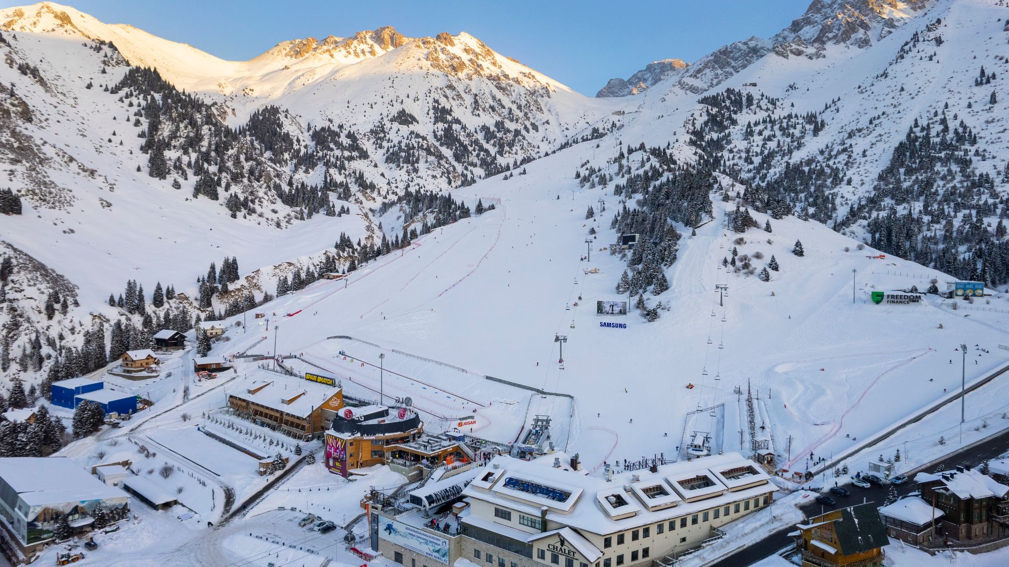 The Shymbulak base at dawn: the hotel, the lift stations and the main slope under the Tian Shan