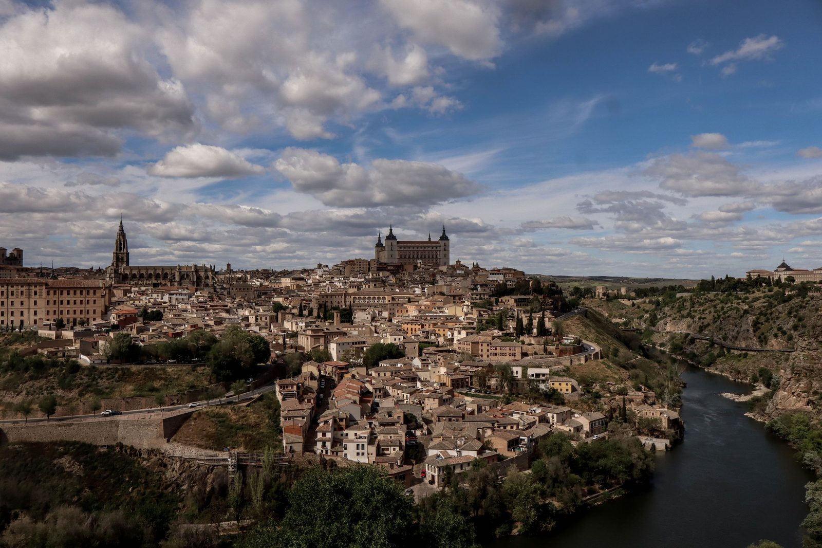 Toledo on its hill above a bend of the Tagus, the cathedral spire and the square block of the Alcázar on the skyline
