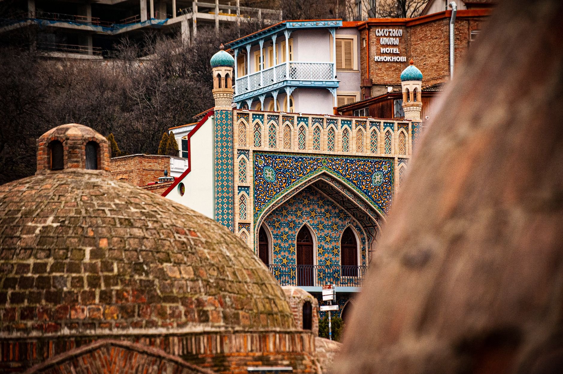 A brick sulphur-bath dome and the blue-tiled facade of the Orbeliani bathhouse in Abanotubani, Tbilisi