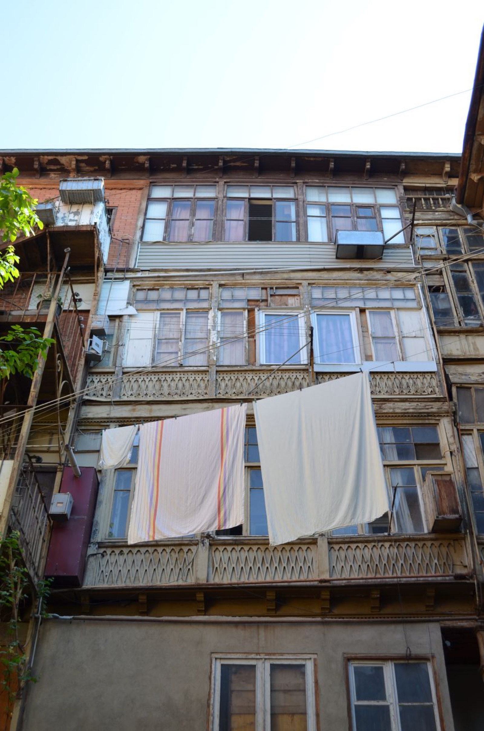 A weathered old-town house in Tbilisi with carved wooden balconies and laundry hung out to dry