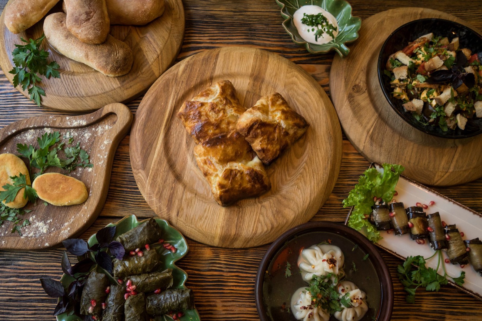 A spread of traditional Georgian dishes on a wooden table, a supra feast