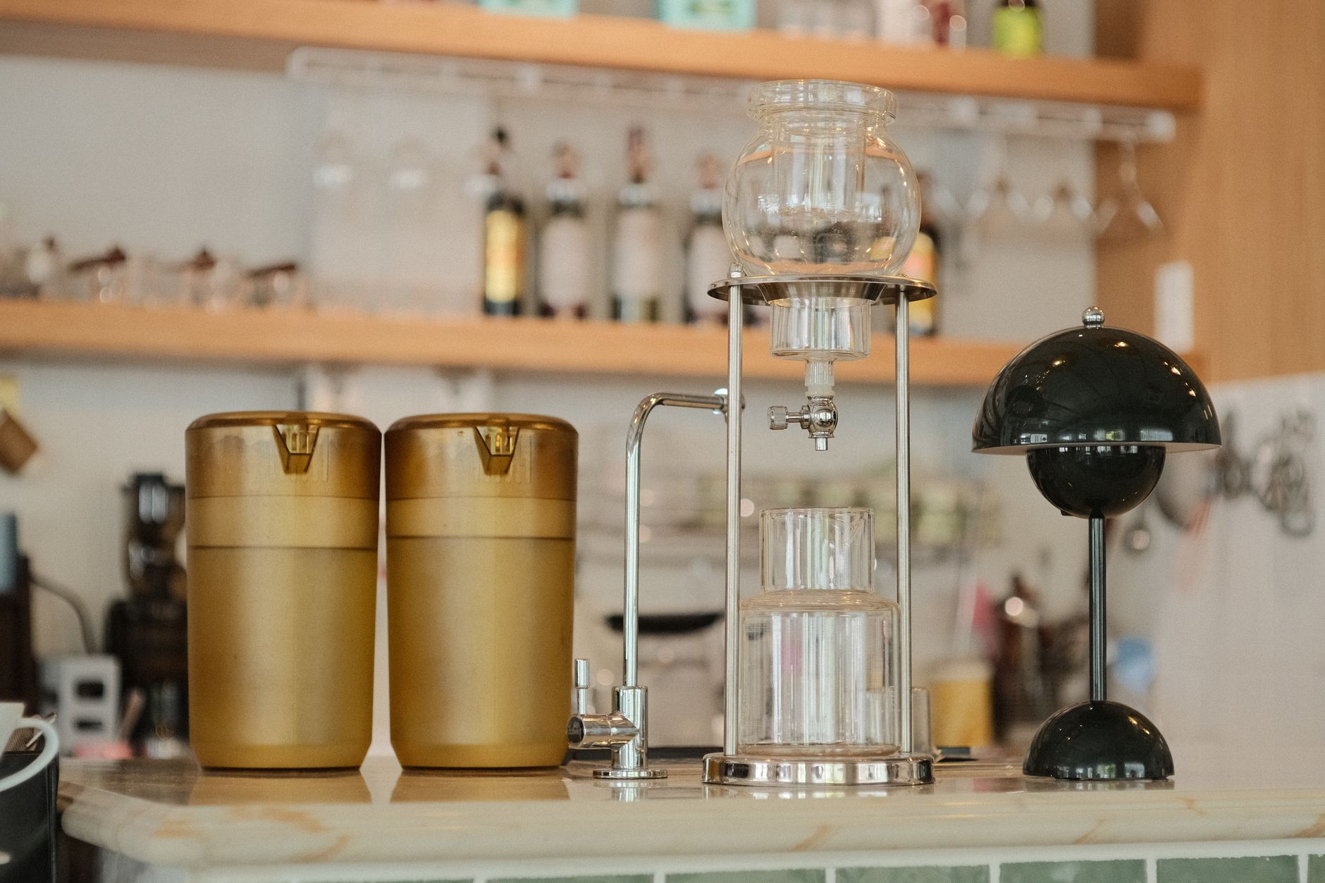The dim interior of an old Japanese coffee house with brewing equipment on a wooden counter
