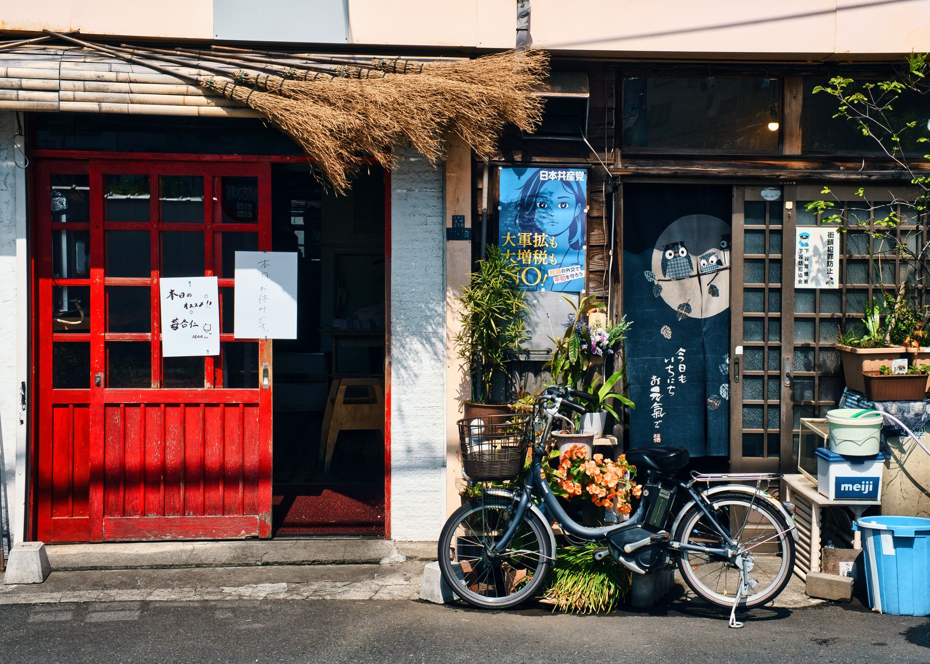 A quiet old street in the Yanaka district of Tokyo, low wooden buildings and lanterns