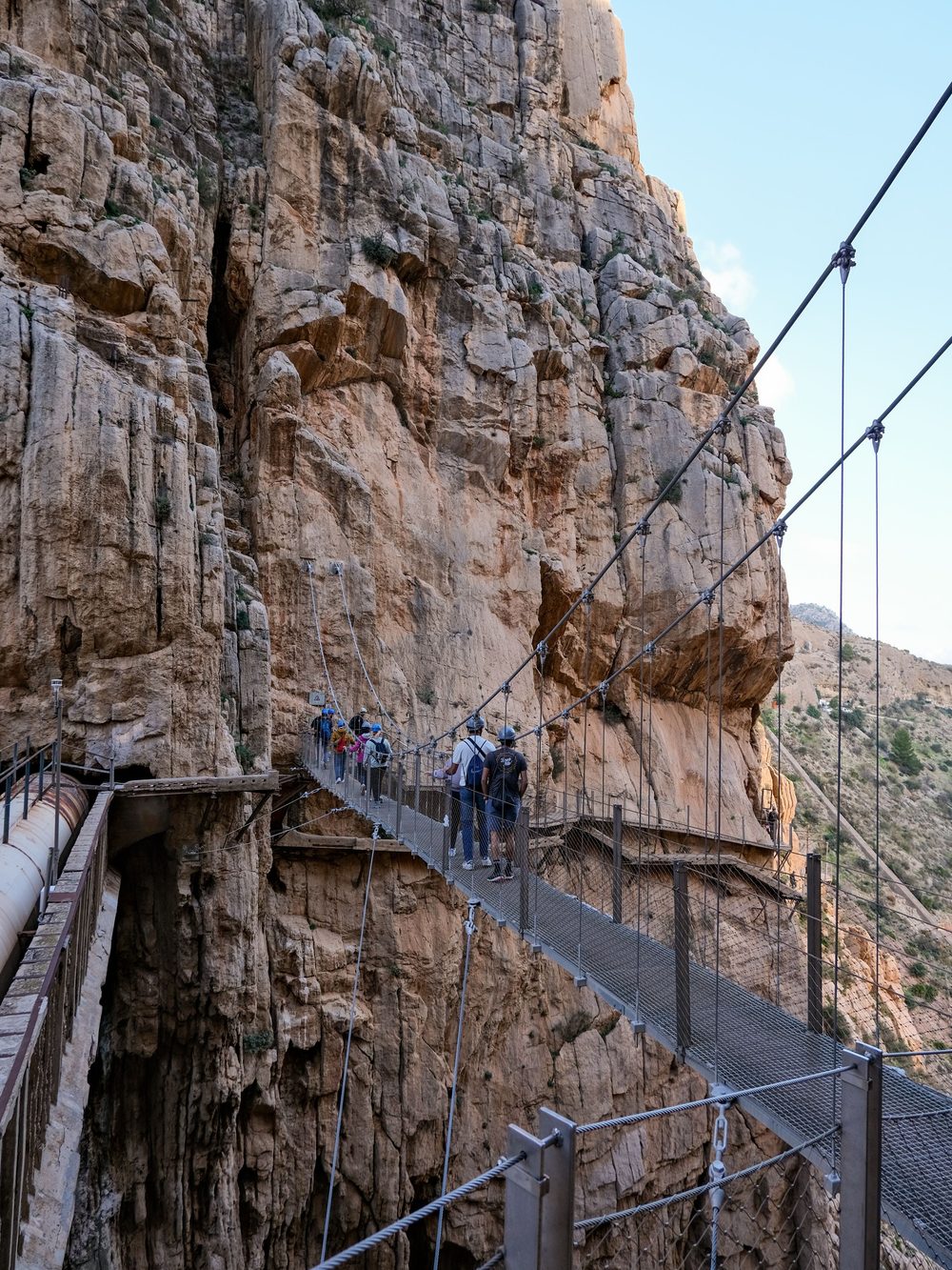 Walkers crossing the hanging bridge high above the Gaitanes gorge