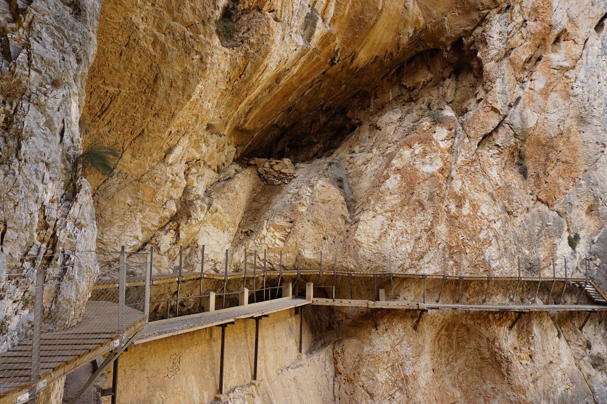 The Caminito del Rey boardwalk fixed under a limestone overhang in the Gaitanes gorge