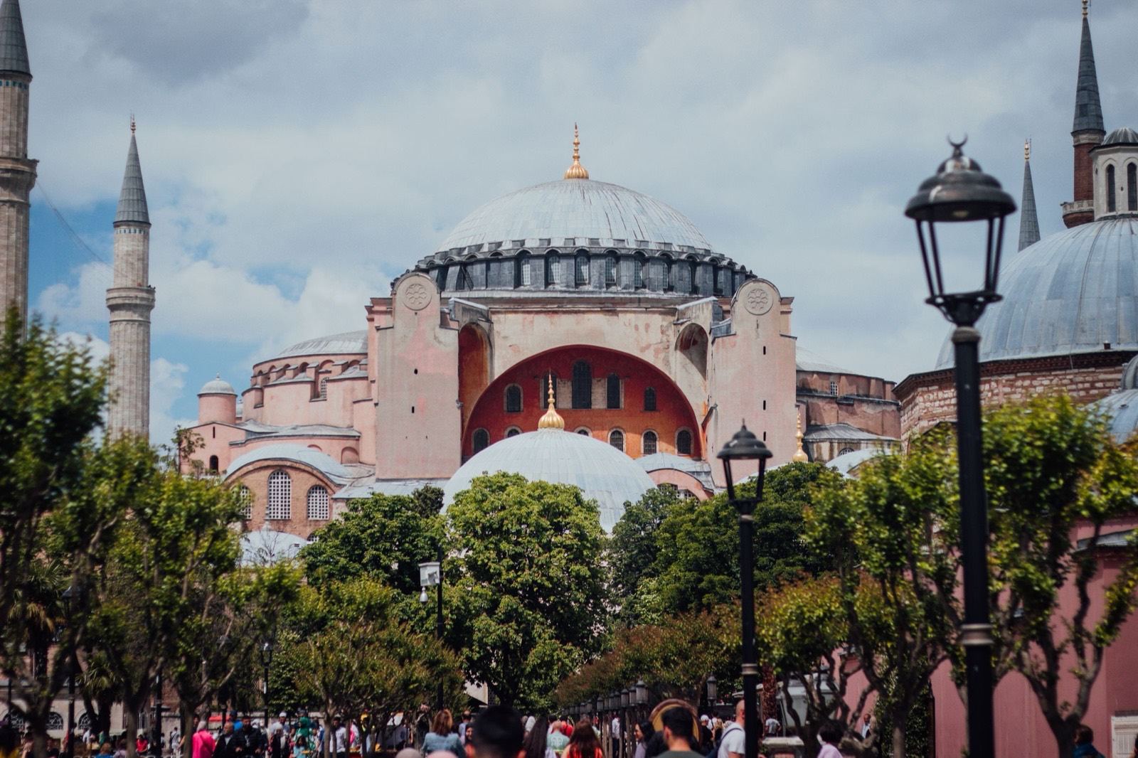 Hagia Sophia's great dome and minarets rising over the trees of Sultanahmet under a cloudy sky