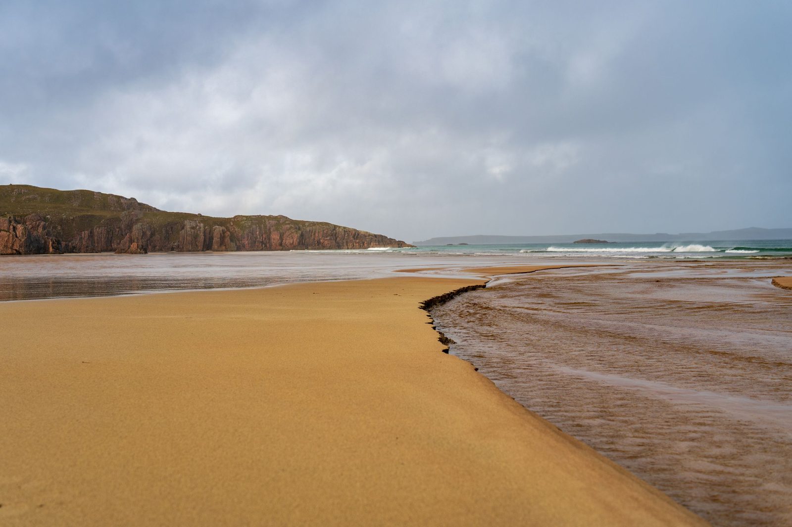 Golden sand, red cliffs and surf on the Durness coast