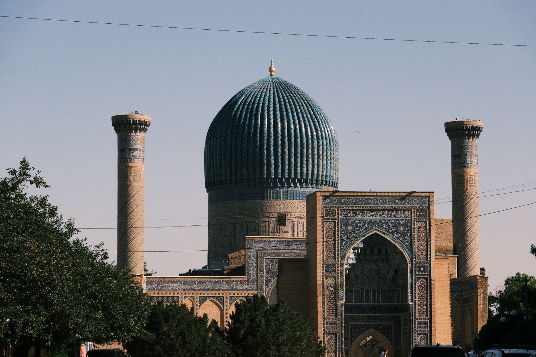 The ribbed turquoise dome of the Gur-e-Amir mausoleum in Samarkand against a pale sky