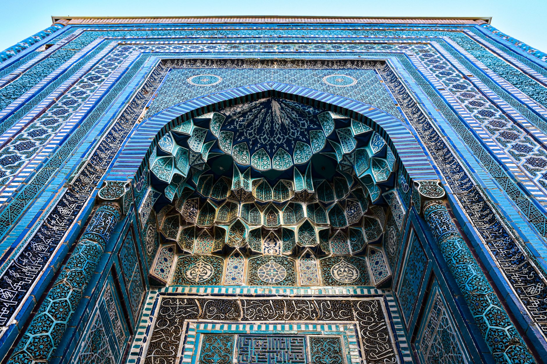A blue-tiled portal in the Shah-i-Zinda necropolis in Samarkand, dense with painted and mosaic tilework