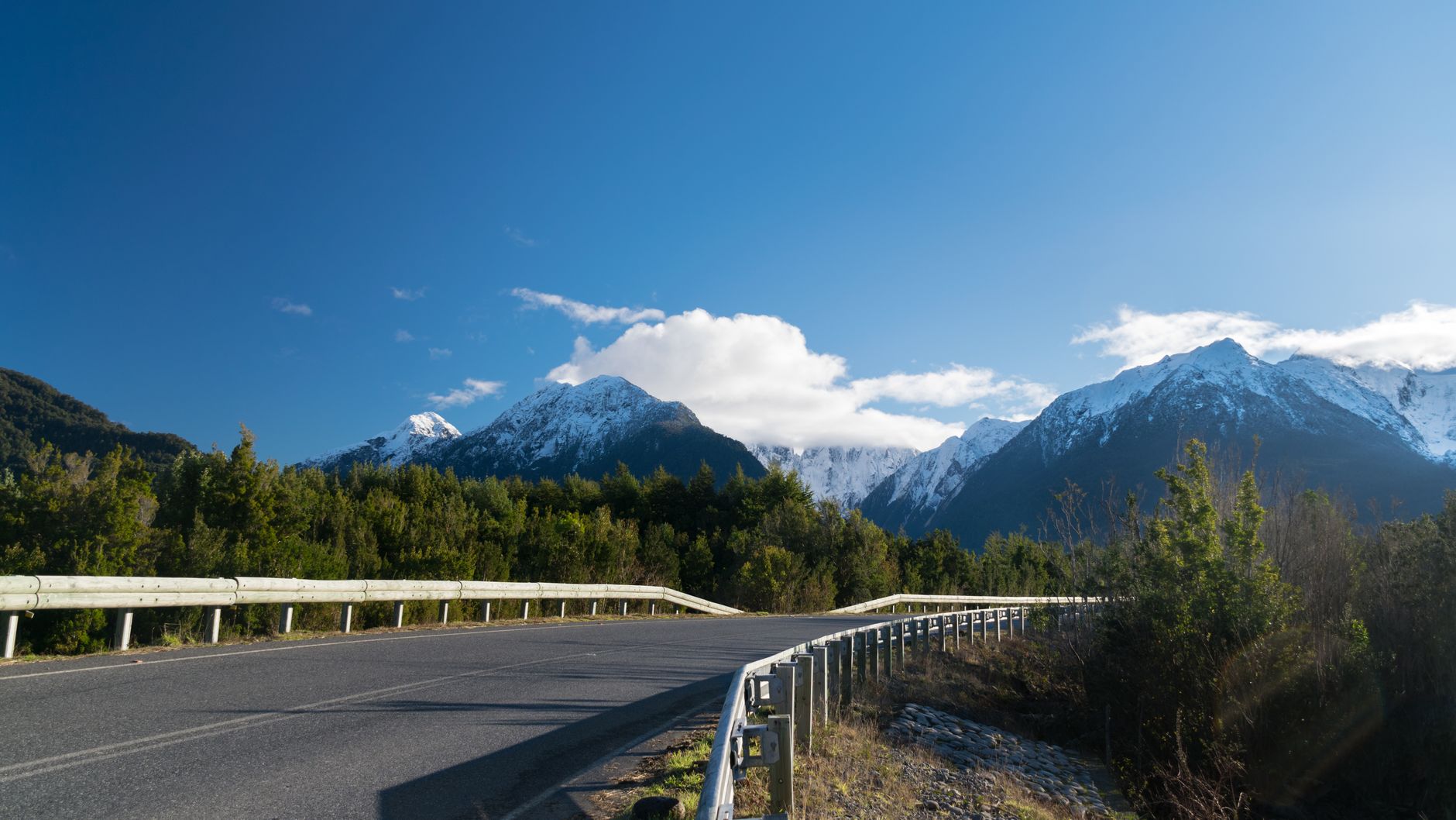 The gravel Carretera Austral running through the valley under the peaks