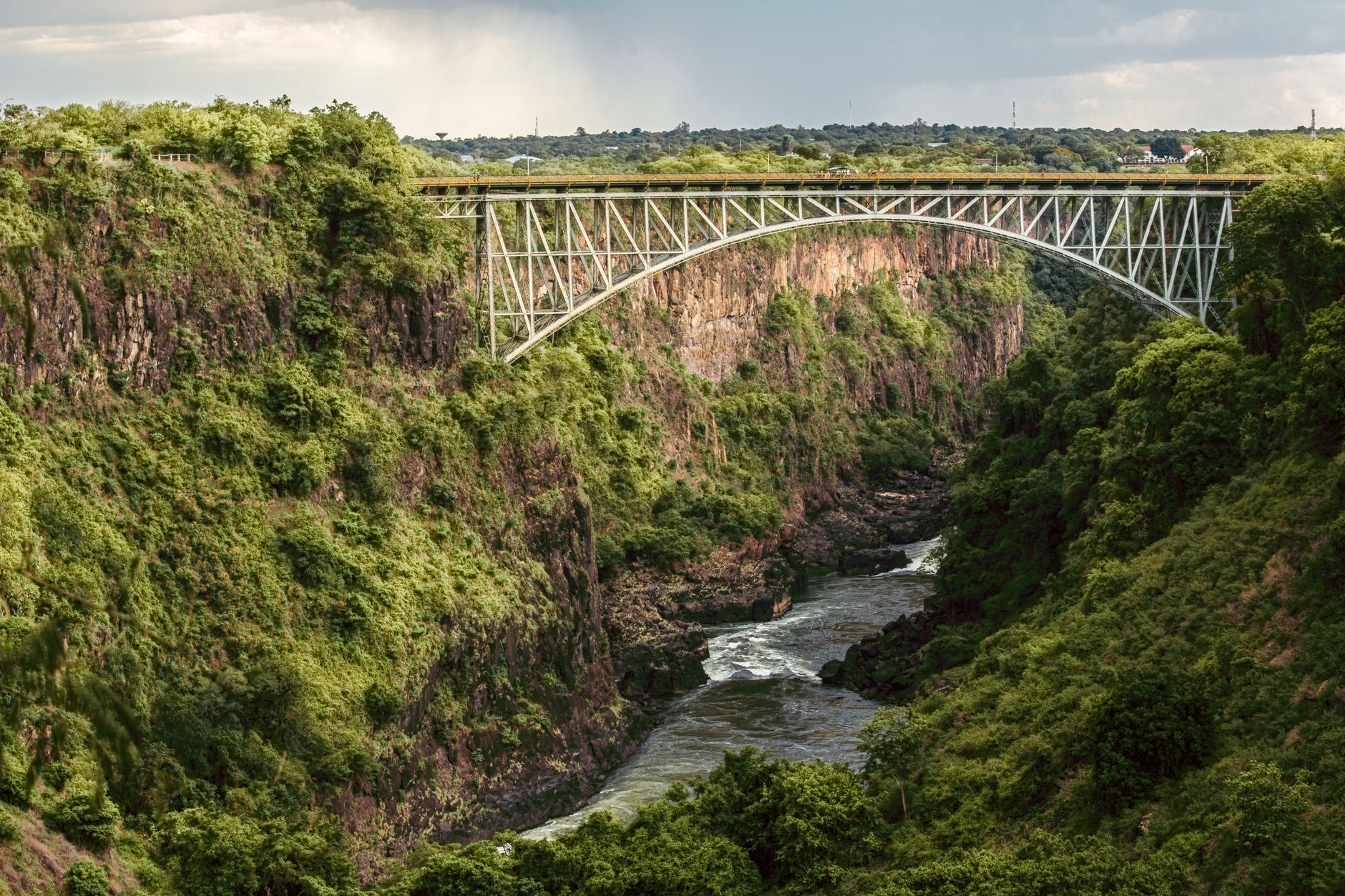The steel arch of the Victoria Falls Bridge spanning the green Batoka Gorge